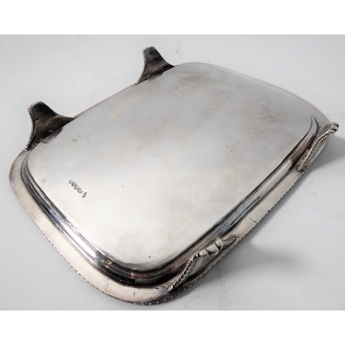 100 - A hallmarked silver salver of rectangular shape; raised gadrooned border and on four shaped feet, ma... 