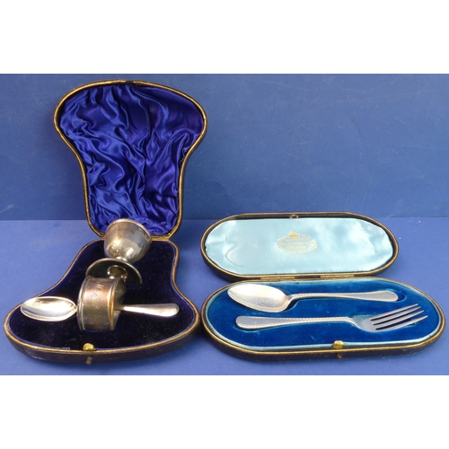 104 - Two cased hallmarked silver sets:

 1. an egg-cup, spoon and napkin-ring set - the egg cup with make... 