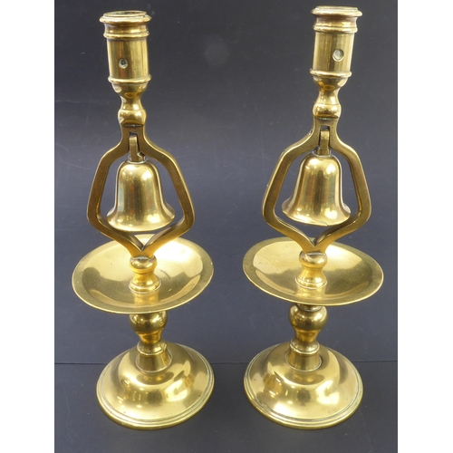 72 - A pair of 19th century cast-brass candlesticks; the middle section with hinged bells (no clappers) (... 