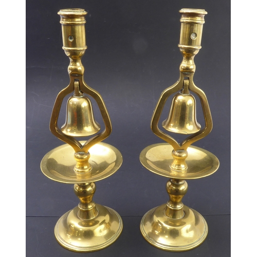 72 - A pair of 19th century cast-brass candlesticks; the middle section with hinged bells (no clappers) (... 