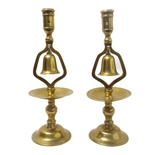 72 - A pair of 19th century cast-brass candlesticks; the middle section with hinged bells (no clappers) (... 