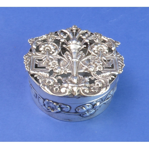 91 - A circular hallmarked silver trinket/silver jewellery box; the elaborately decorated and pierced cov... 