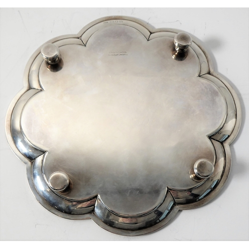 99 - A heavy hallmarked silver salver of flowerhead shape and raised on four bun-style feet' maker's mark... 