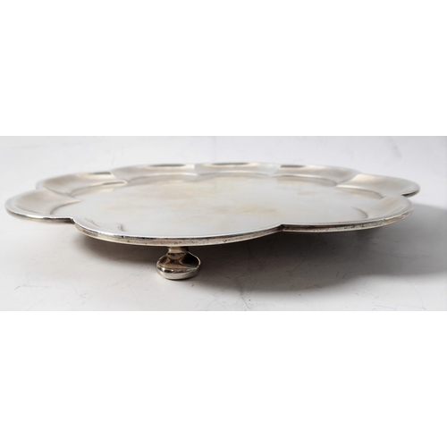 99 - A heavy hallmarked silver salver of flowerhead shape and raised on four bun-style feet' maker's mark... 