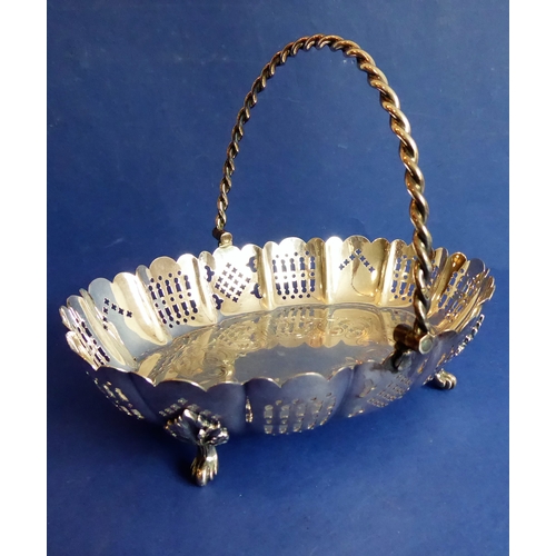 120 - A heavy hallmarked silver cake basket  rope-twist-style swing-handle above a castellated-style pier... 