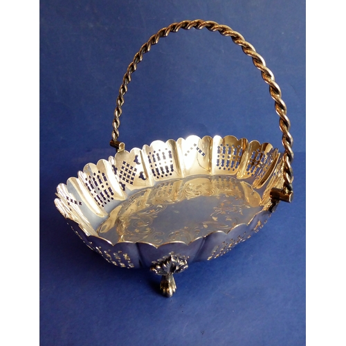 120 - A heavy hallmarked silver cake basket  rope-twist-style swing-handle above a castellated-style pier... 