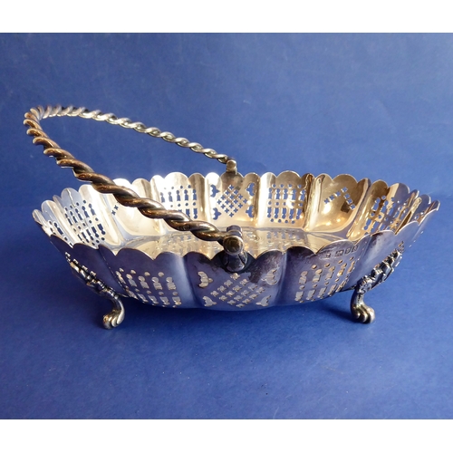 120 - A heavy hallmarked silver cake basket  rope-twist-style swing-handle above a castellated-style pier... 