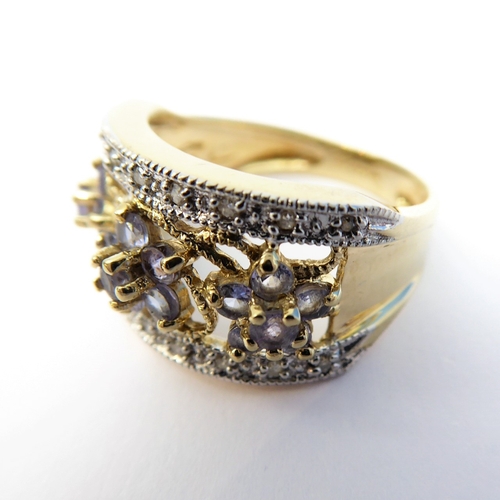 101 - A 9-carat gold dress ring set with small tanzanites and diamonds (boxed), ring size K/L