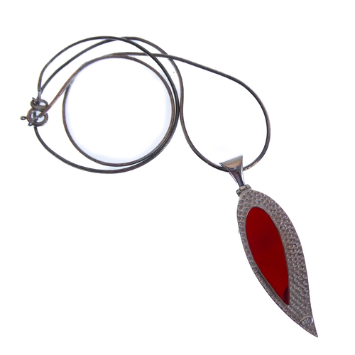 117 - An unusual silver mounted and red hardstone inverted teardrop-shaped pendant upon a silver chain, in... 