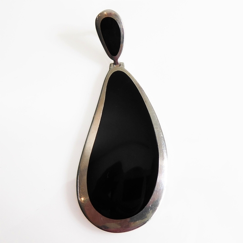 118 - A large silver-mounted pendant set with two polished black hardstones