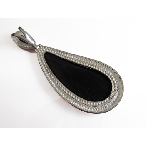 118 - A large silver-mounted pendant set with two polished black hardstones