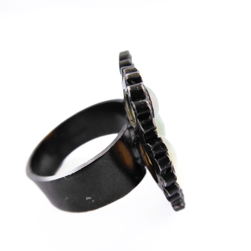 122 - An unusual black lacquered silver ring set with seven opals surrounded by small diamonds, ring size ... 