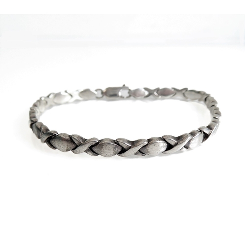 128 - A heavy silver bracelet modelled as alternating crosses and lozenges