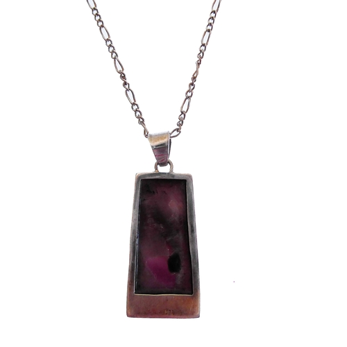 130 - An unusual silver pendant of tapering rectangular form and mounted with a dark amethyst-style polish... 