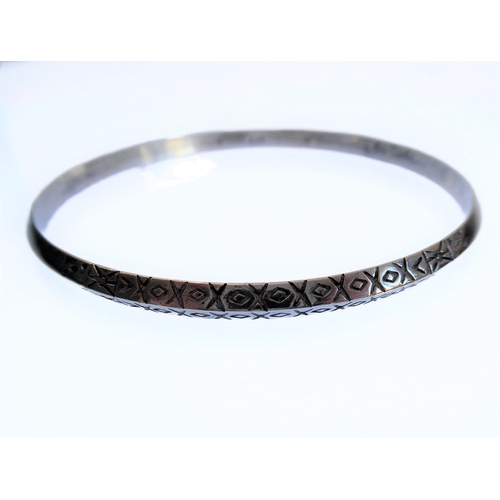 136 - A silver bangle engraved with a double band of horizontal lozenges