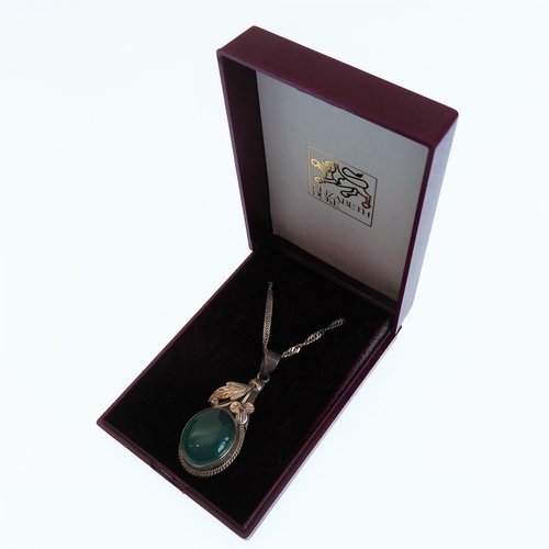 137 - A silver pendant mounted with a green hardstone polished en cabochon, upon a silver chain (boxed)