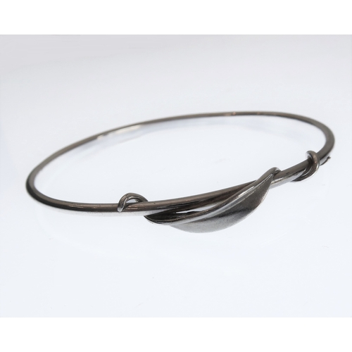 141 - A silver bangle with a spiralling leaf twist design