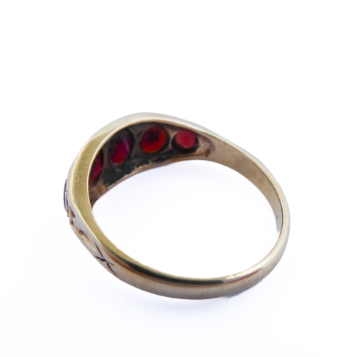 143 - A 9-carat gold gipsy-style ring set with five graduated garnets, ring size R/S