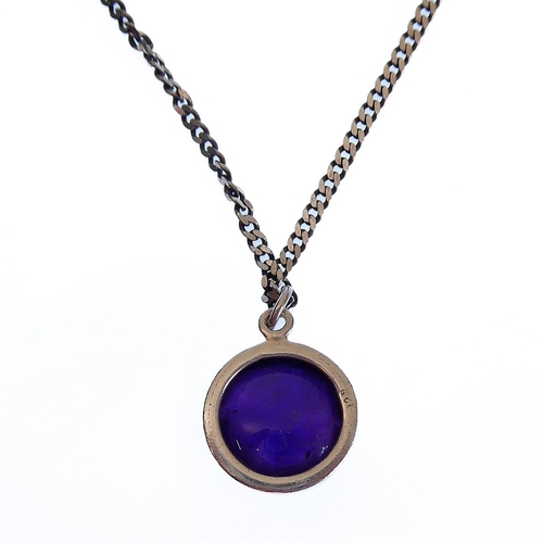 144 - A circular silver pendant mounted with an amethyst-coloured hardstone polished en cabochon, together... 