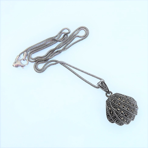 155 - A scallop-shell-shaped Art-Deco-style silver marquisate-mounted pendant on a silver chain (boxed)