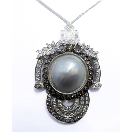 158 - An 18-carat white gold pendant centred with a large mabé pearl surrounded by champagne diamonds and ... 