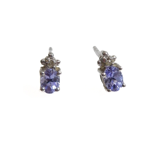 159 - A pair of silver stud earrings mounted with tanzanite stones and (possibly diamond) chips