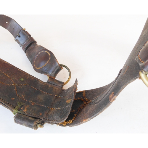 172 - An early 20th century Sam Browne belt, a heavy brass bridle buckle and two leather straps