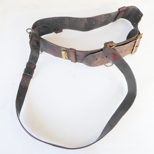 172 - An early 20th century Sam Browne belt, a heavy brass bridle buckle and two leather straps