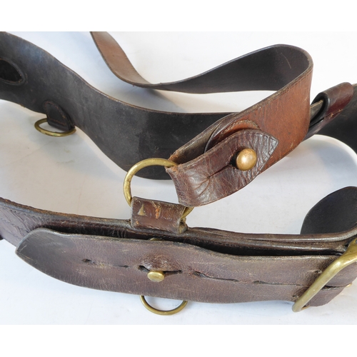 172 - An early 20th century Sam Browne belt, a heavy brass bridle buckle and two leather straps