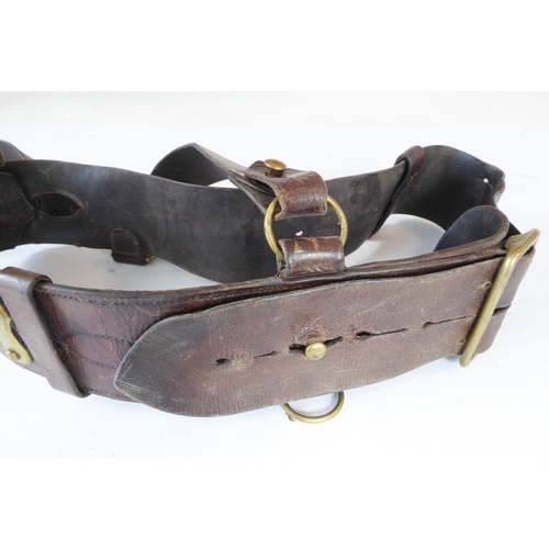 172 - An early 20th century Sam Browne belt, a heavy brass bridle buckle and two leather straps