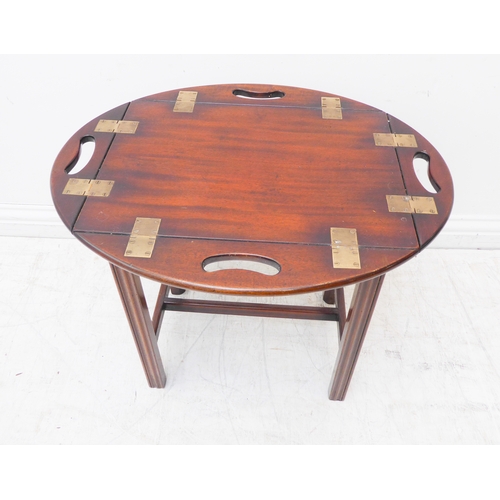 313 - A small oval folding mahogany butler's tray on stand (as a table) with brass hinges and folding side... 