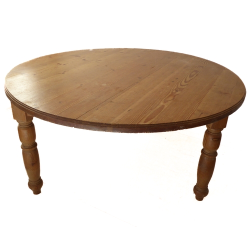 384 - A large circular farmhouse-style pine table with three turned legs (151cm diameter x 78cm high)