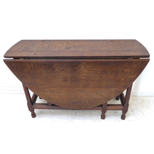 387 - An 18th century oval oak gateleg table: the well-figured top with medullary rays above a plain friez... 