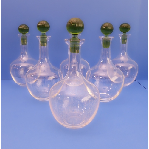 67 - A set of six Murano decanters; clear-glass onion bodies and green-glass stoppers (28cm high)