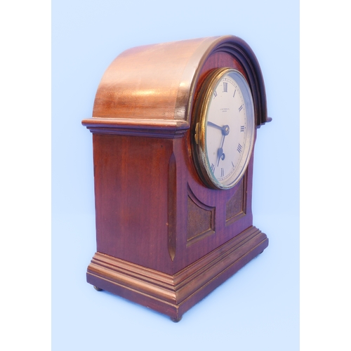 164 - An early 20th century mahogany-cased mantle clock: the silver-coloured dial with Roman numerals and ... 