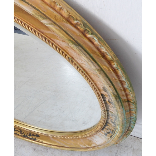 235 - A 19th century style (modern reproduction) oval gilt framed wall-hanging looking glass having hand-b... 