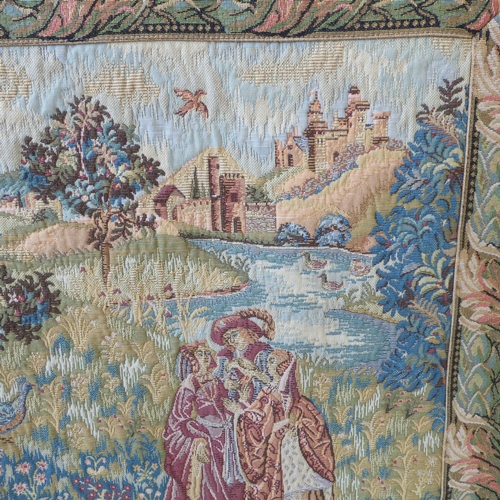 269 - A wall-hanging cotton tapestry depicting a medieval style scene with buildings, castles, a lake, fig... 