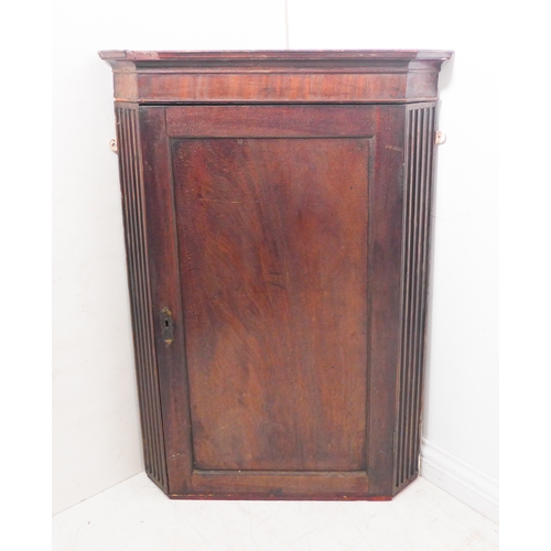 300 - A late 18th century mahogany hanging corner cupboard: the single panelled door opening to reveal gre... 