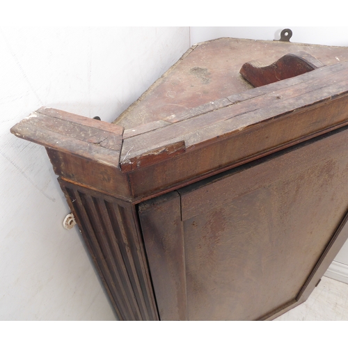 300 - A late 18th century mahogany hanging corner cupboard: the single panelled door opening to reveal gre... 