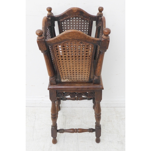 309 - An early 20th century oak and rattan cane-sided plant stand on base with turned legs and carved scro... 