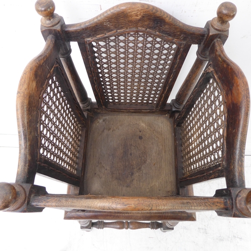 309 - An early 20th century oak and rattan cane-sided plant stand on base with turned legs and carved scro... 