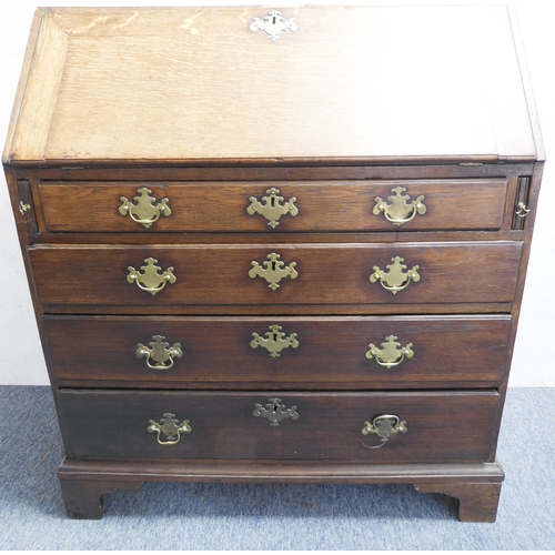 310 - A mid-18th century oak writing bureau: the angular cleated fall opening to reveal fitted interior of... 