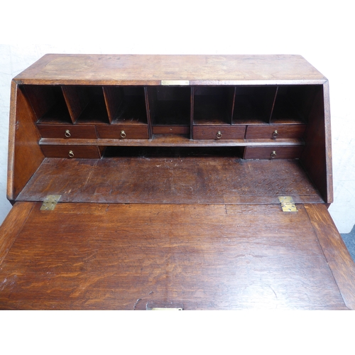 310 - A mid-18th century oak writing bureau: the angular cleated fall opening to reveal fitted interior of... 