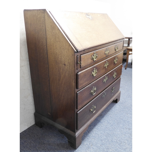 310 - A mid-18th century oak writing bureau: the angular cleated fall opening to reveal fitted interior of... 