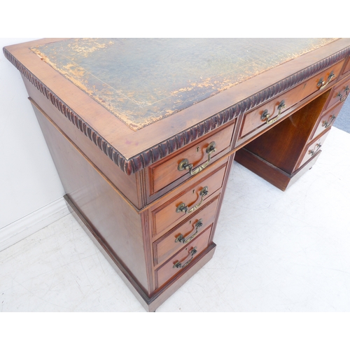 327 - An early 20th century walnut pedestal desk: the leather inset top with gadrooned moulding an arrange... 