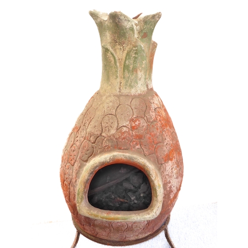 443 - A terracotta chimenea on shaped iron stand: approx. 112cm high including stand