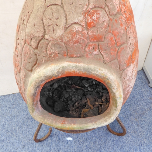 443 - A terracotta chimenea on shaped iron stand: approx. 112cm high including stand