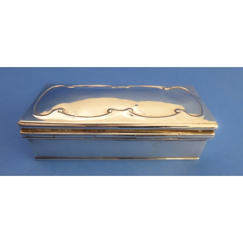 90 - A hallmarked silver box and hinged cover: the slightly domed cover decorated with continuous C-scrol... 