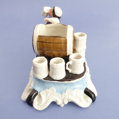 19 - A late 19th century German porcelain fairing match-holder modelled as a brewer sampling beer