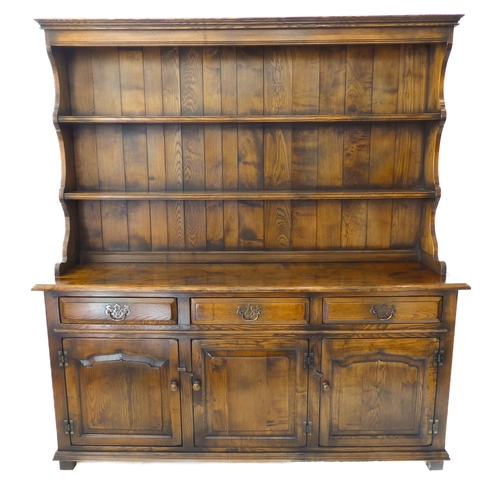 391 - A good and large reproduction solid oak dresser: the shelved superstructure above three frieze drawe... 